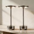 Two silver Cordless Metal Table Lamps casting warm light on a travertine console.