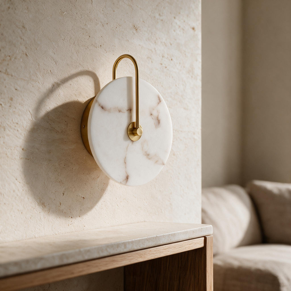 Sculptural Disc Wall Light — veined white shade and gold-tone frame in an ivory interior