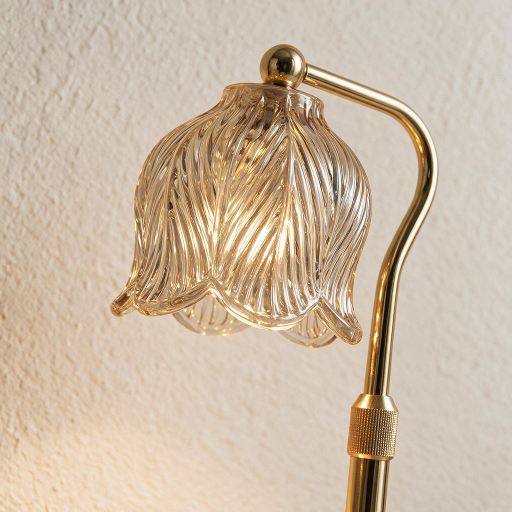 Close-up of the Tulip Candle Warmer Lamp's sculpted clear glass shade and curved gold stem.