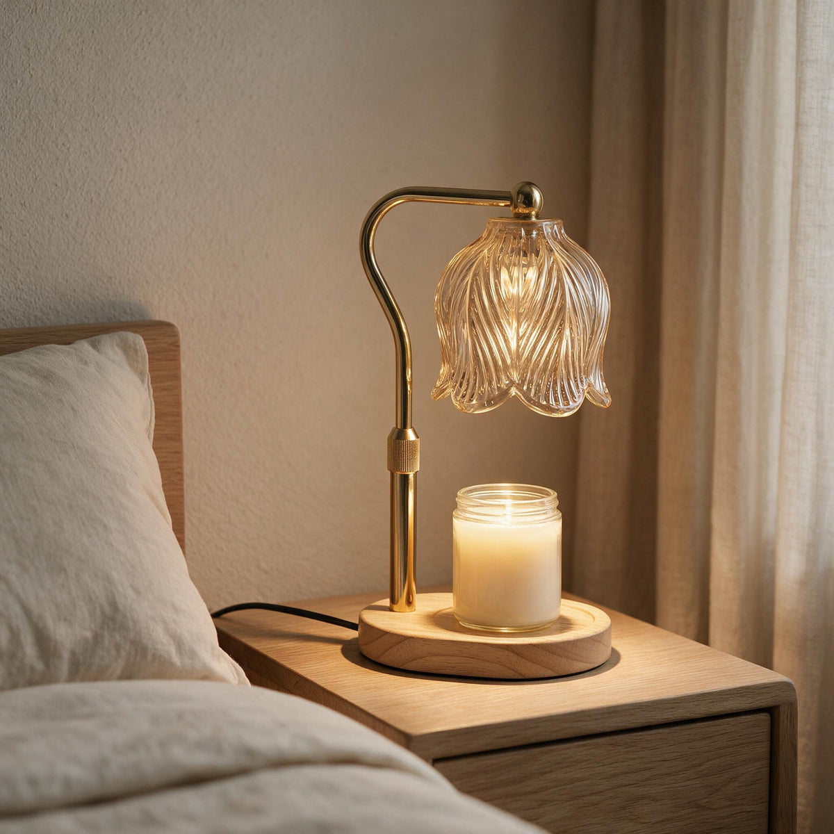 Gold Tulip Candle Warmer Lamp with an unlit jar candle on an oak bedside table.